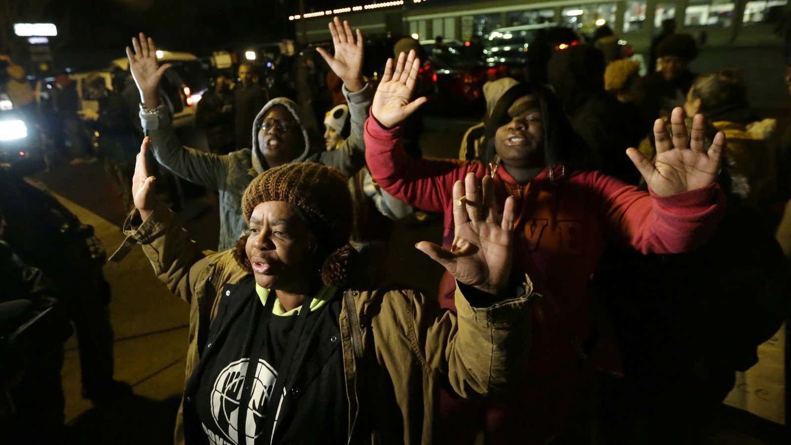 Barbara Jones, joined by other protesters, raises her hands, Monday, Nov. 24, 2014, in Ferguson, Mo., more than three months after an unarmed black 18-year-old man was shot and killed there by a white policeman.