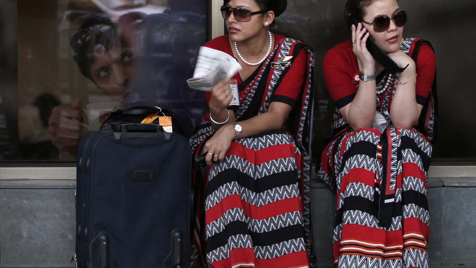Air India air hostesses sit outside the domestic airport as part of a strike in New Delhi May 25, 2010. About 25,000 Air India employees,…
