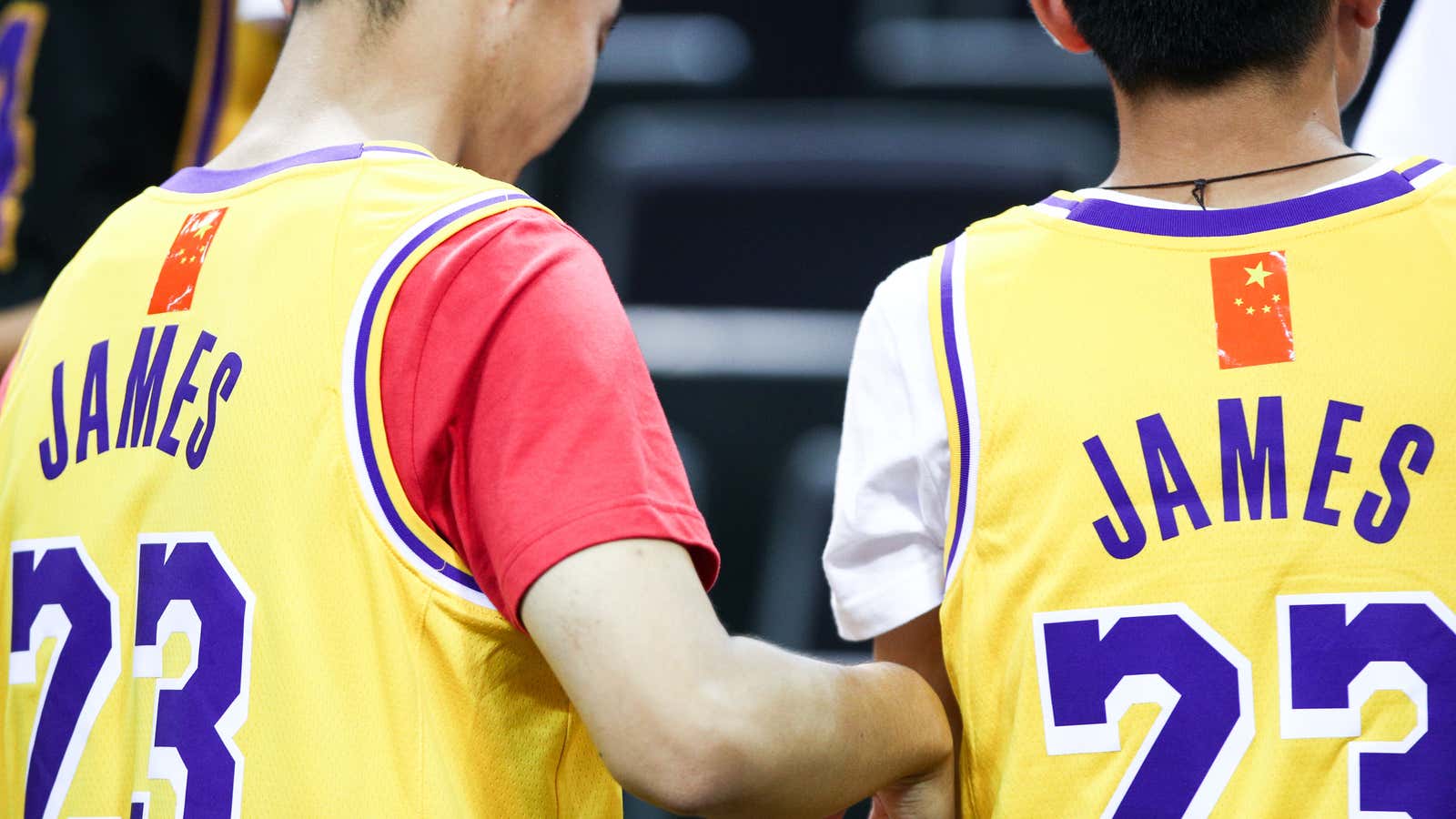 Fans of LeBron James use a Chinese national flag to cover the NBA logo while attending a preseason game between the Los Angeles Lakers and Brooklyn Nets.