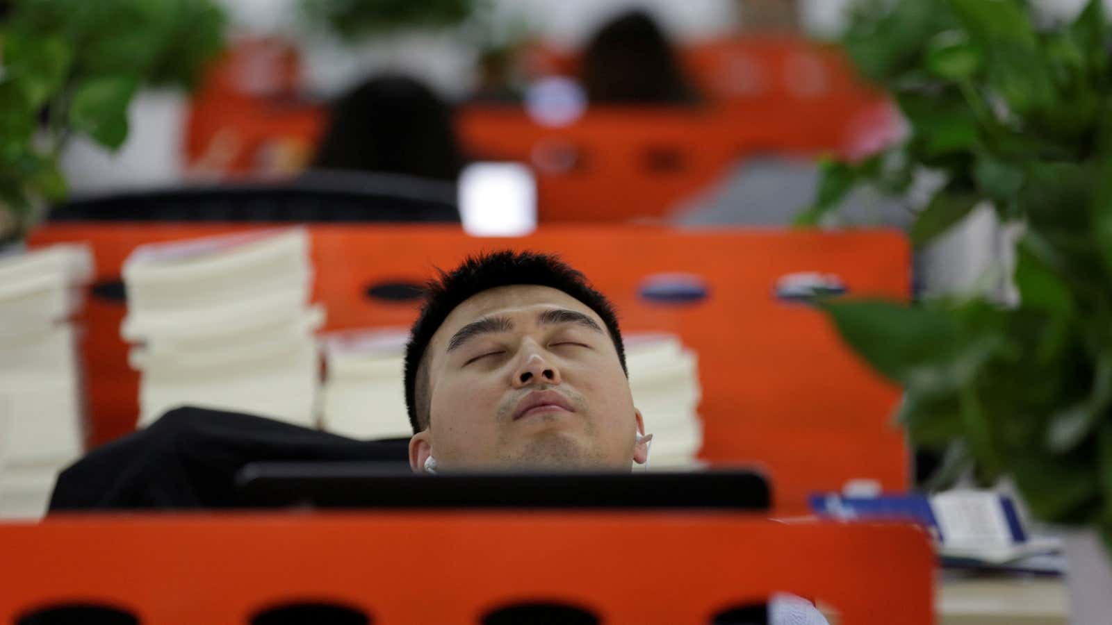 Cui Meng, a Co-founder of Goopal Group, takes a nap in his seat after lunch, in Beijing, China, April 21, 2016. Office workers sleeping on…
