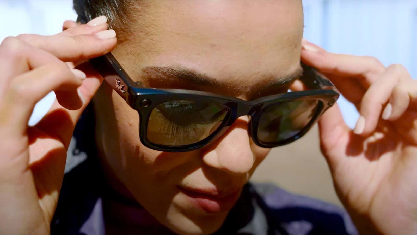 A model tries on a pair of Ray-Ban Stories smart glasses. 