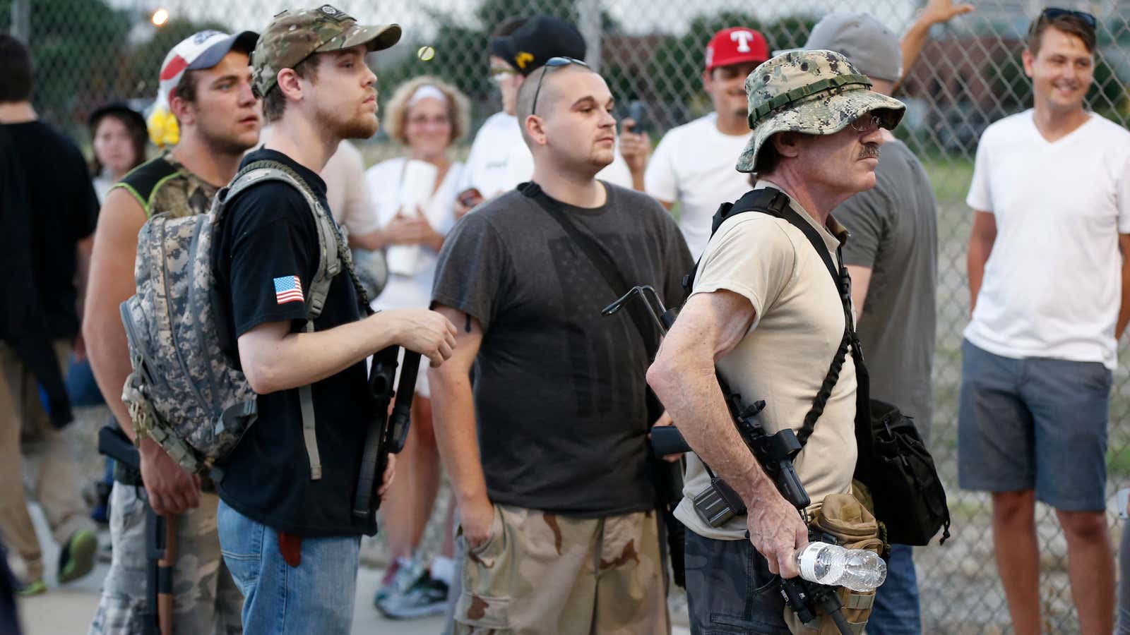 Men carry guns outside a Trump campaign rally in June.