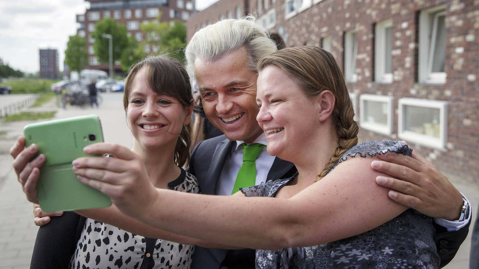 Geert Wilders, leader of the Dutch Freedom Party, poses for a selfie with supporters after casting his vote on May 22.