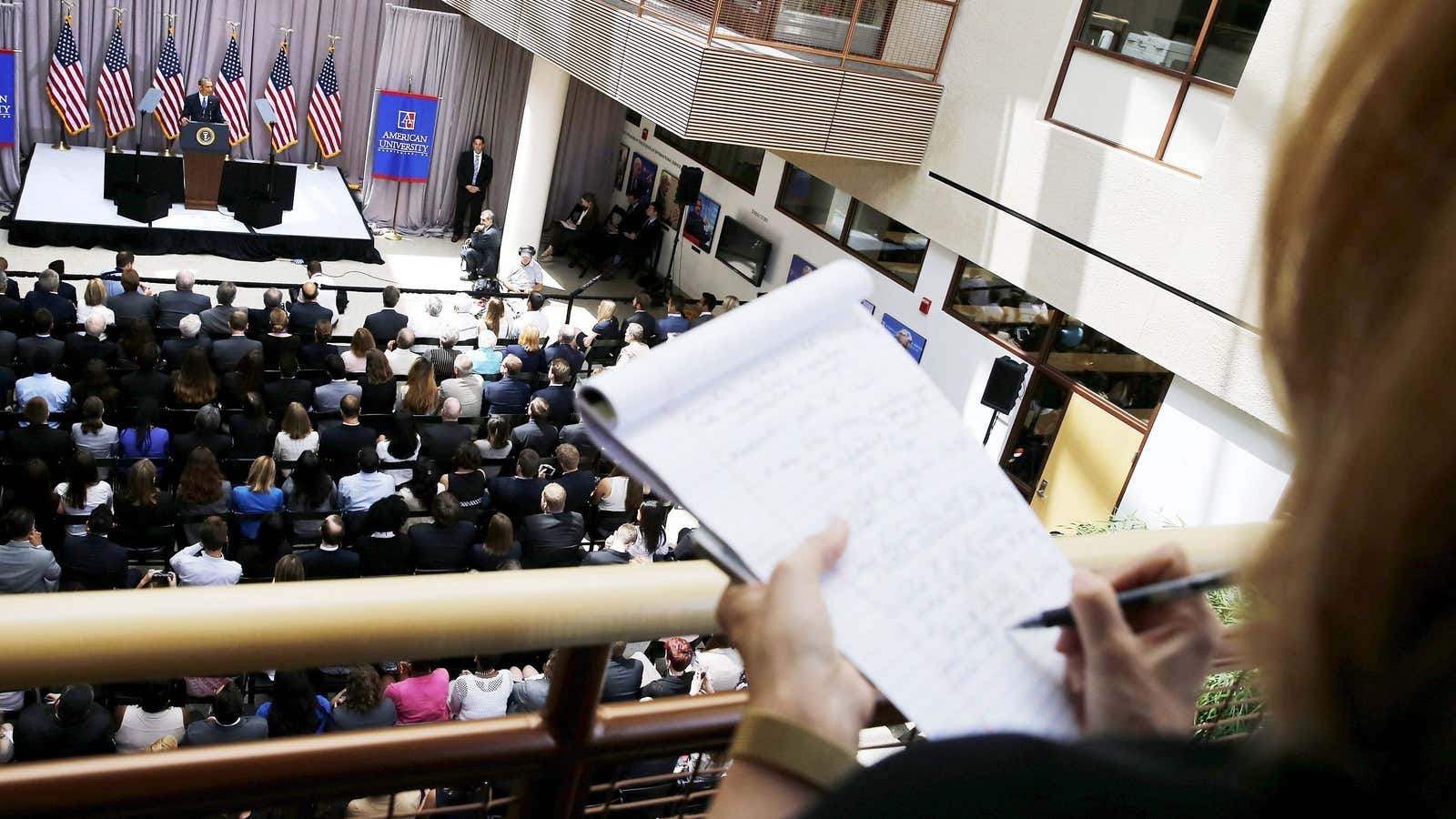 A reporter takes notes from a balcony as U.S. President Barack Obama delivers remarks on a nuclear deal with Iran at American University in Washington…