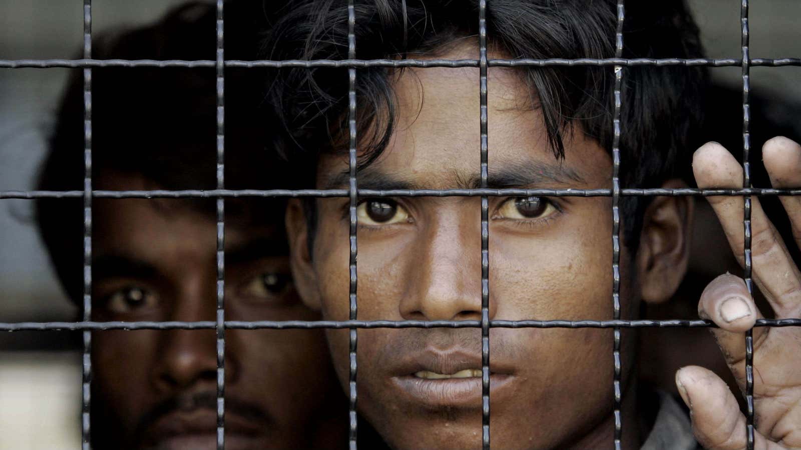 Rohingya migrants look out from the window of a Thai police van in 2009.