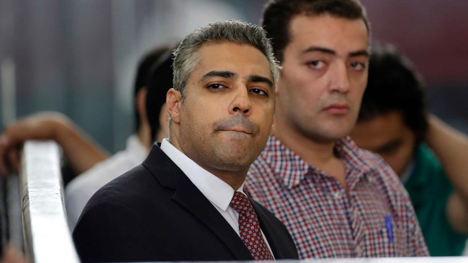 Canadian Al-Jazeera English journalist Mohammed Fahmy, left, and his Egyptian colleague Baher Mohammed listen in a courtroom in Tora prison in Cairo, Egypt back in June.