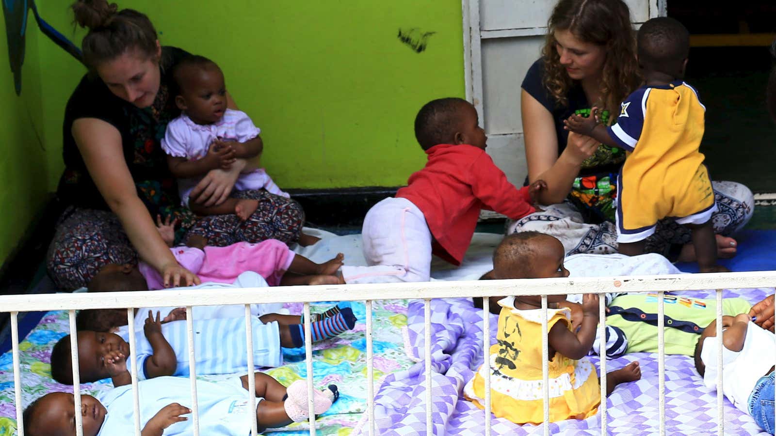 Local and foreign volunteers play with abandoned babies at children at a home in Uganda’s capital, Kampala