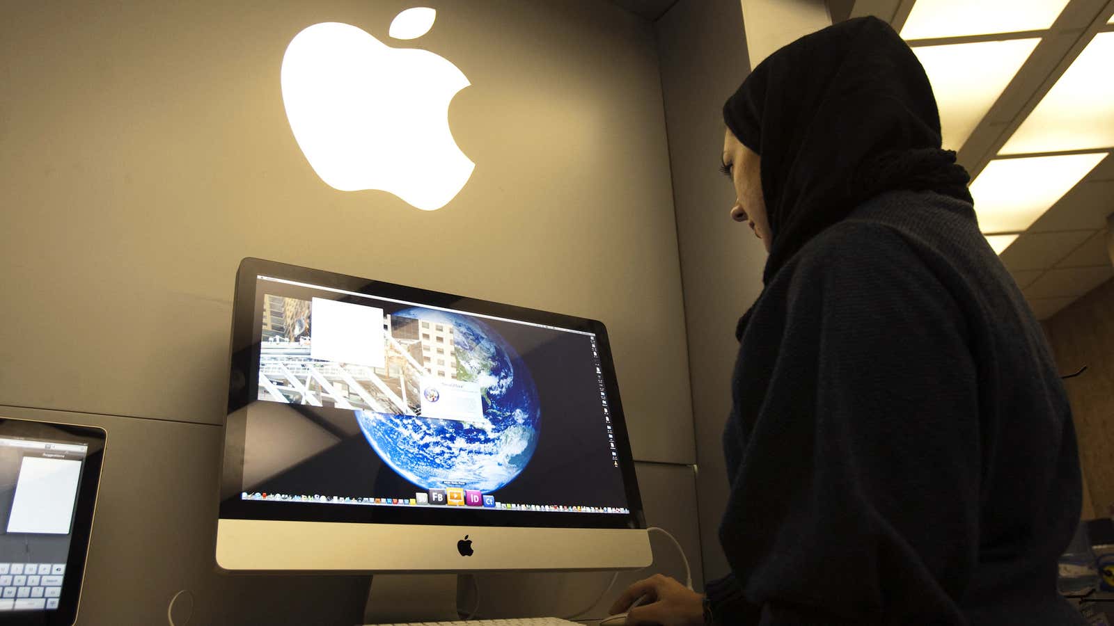 A woman uses an iMac computer in a shop at a mobile and computer shopping complex in northern Tehran on Jan. 18, 2011