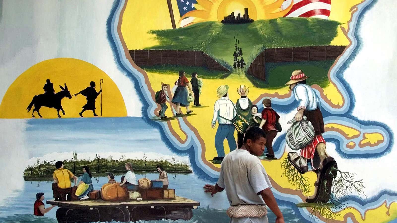 A Honduran migrant stands in front of a mural in the northwest Guatemalan border city of Tecun Uman on May 13, 2001.
