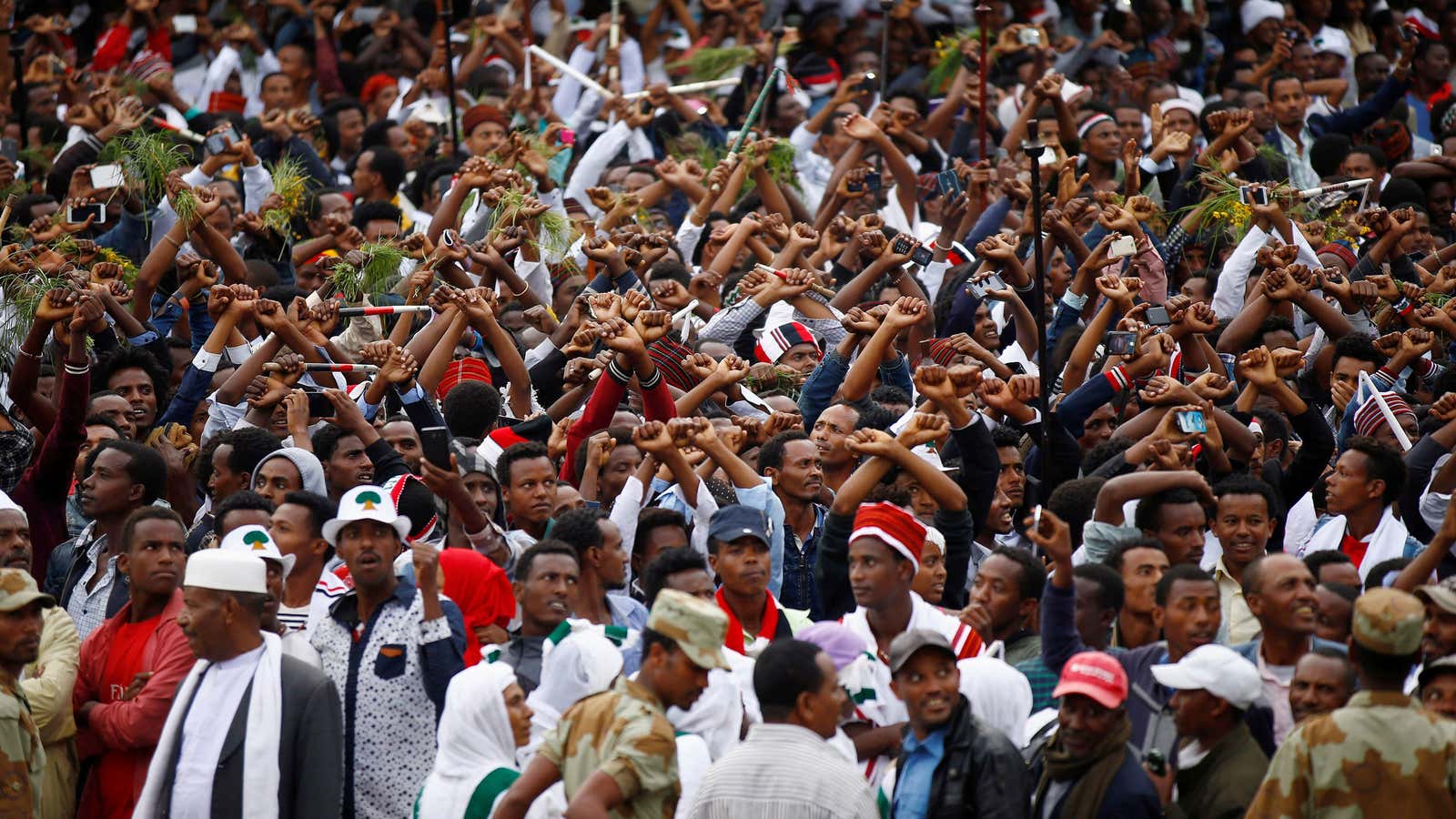 Demonstrators chant slogans while flashing the Oromo protest gesture in October.