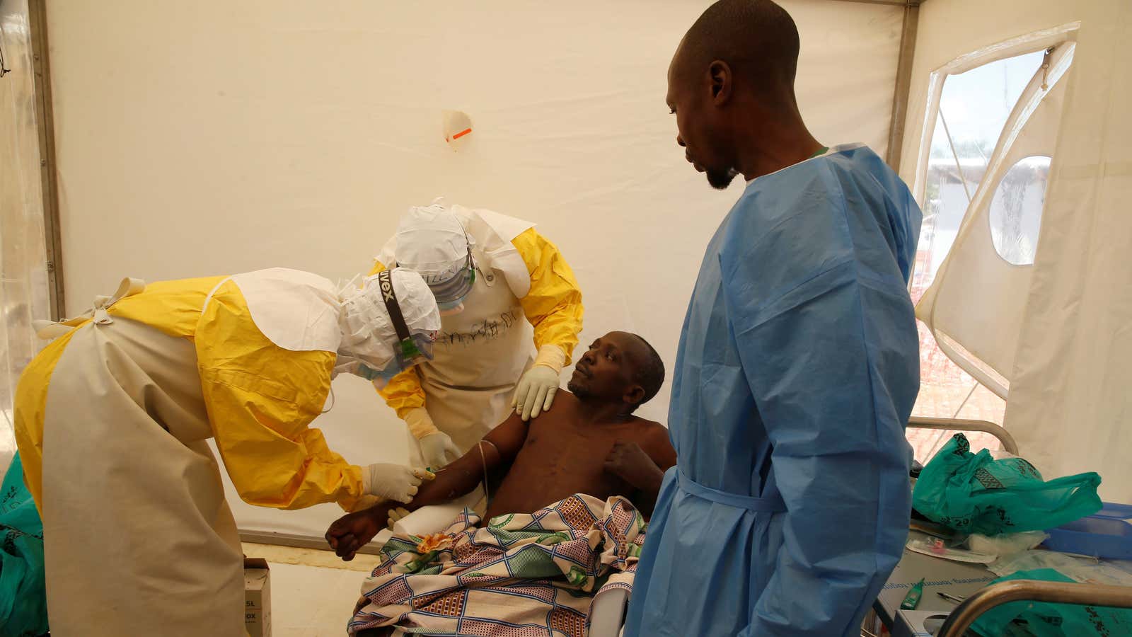Medical staff and an Ebola survivor treat an Ebola patient at a treatment centre in Beni, DR Congo, Mar. 31, 2019.