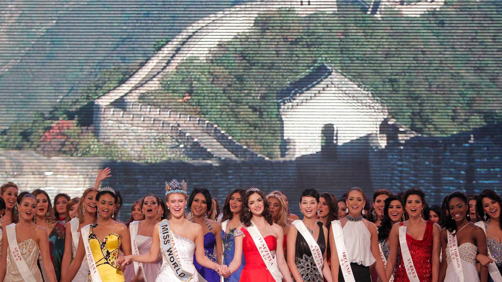 Miss World contestants in front of a screen showing the Great Wall in 2010.