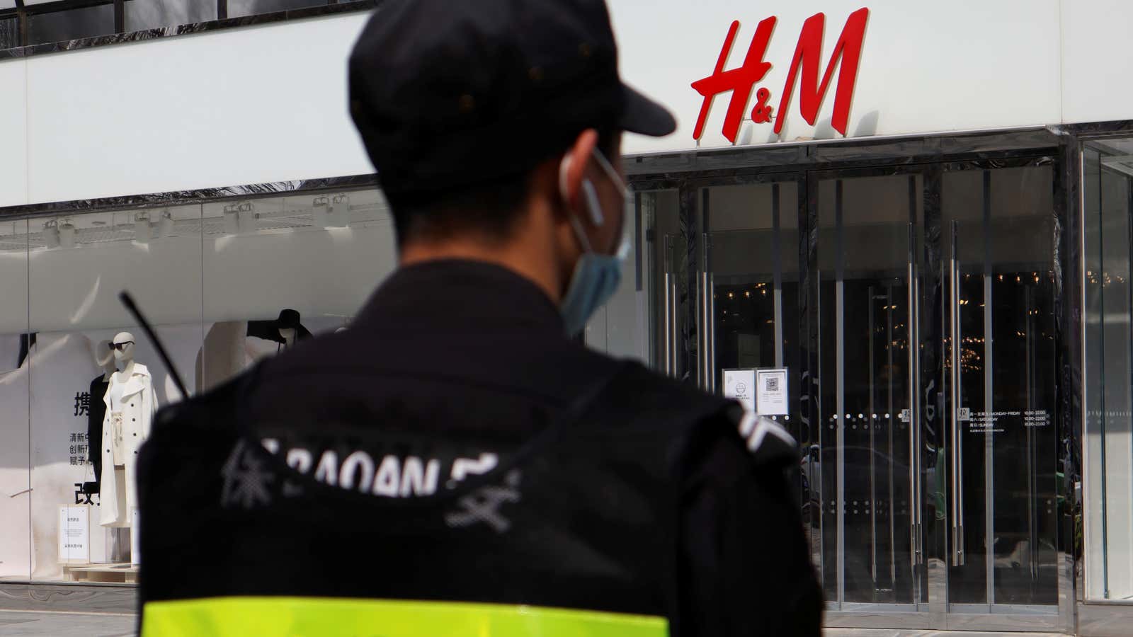 A security guard stands outside a store of the Swedish fashion retailer H&amp;M at a shopping complex in Beijing, China March 25, 2021. REUTERS/Florence Lo