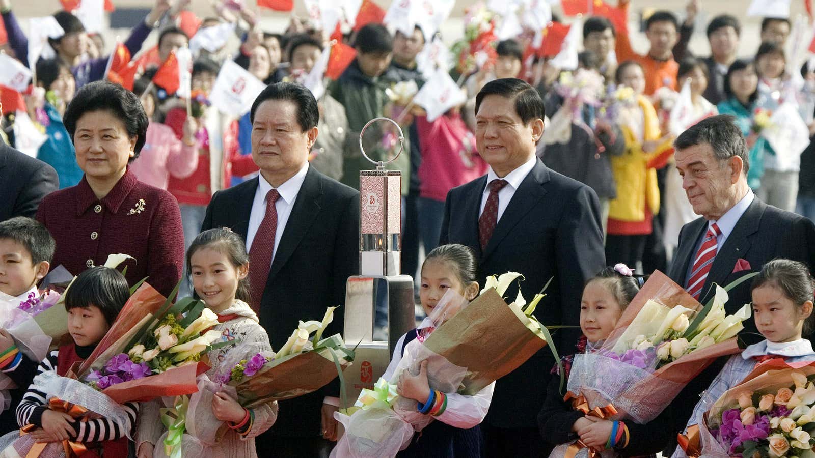 Flower girls and a greeting committee surround Zhou, second from the left, in happier times.