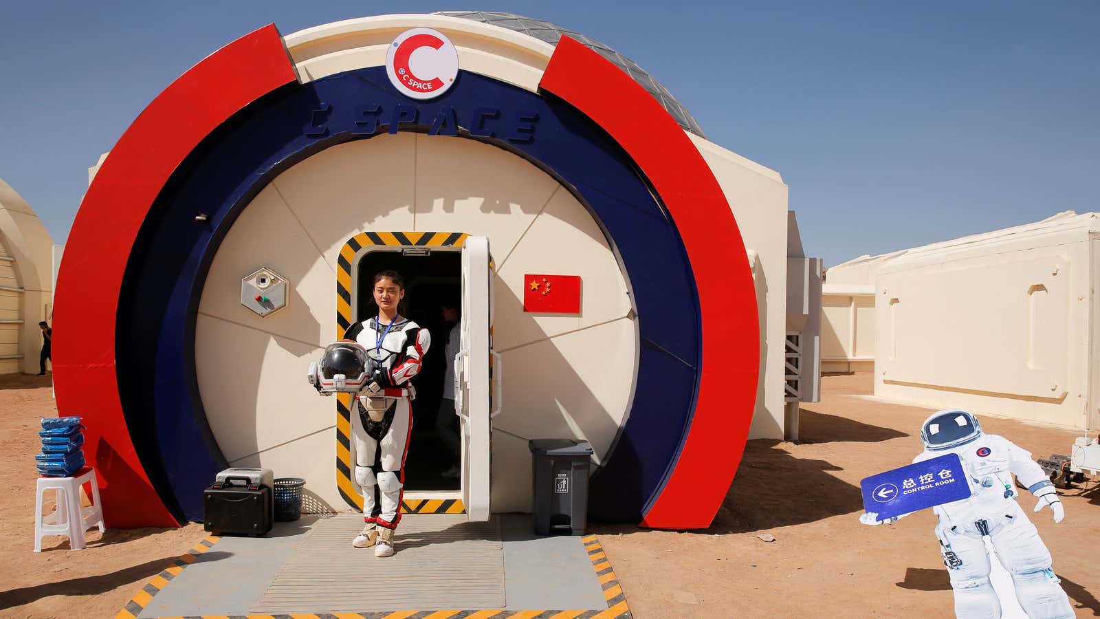 A staff member poses in a mock space suit at the C-Space Project Mars simulation base.