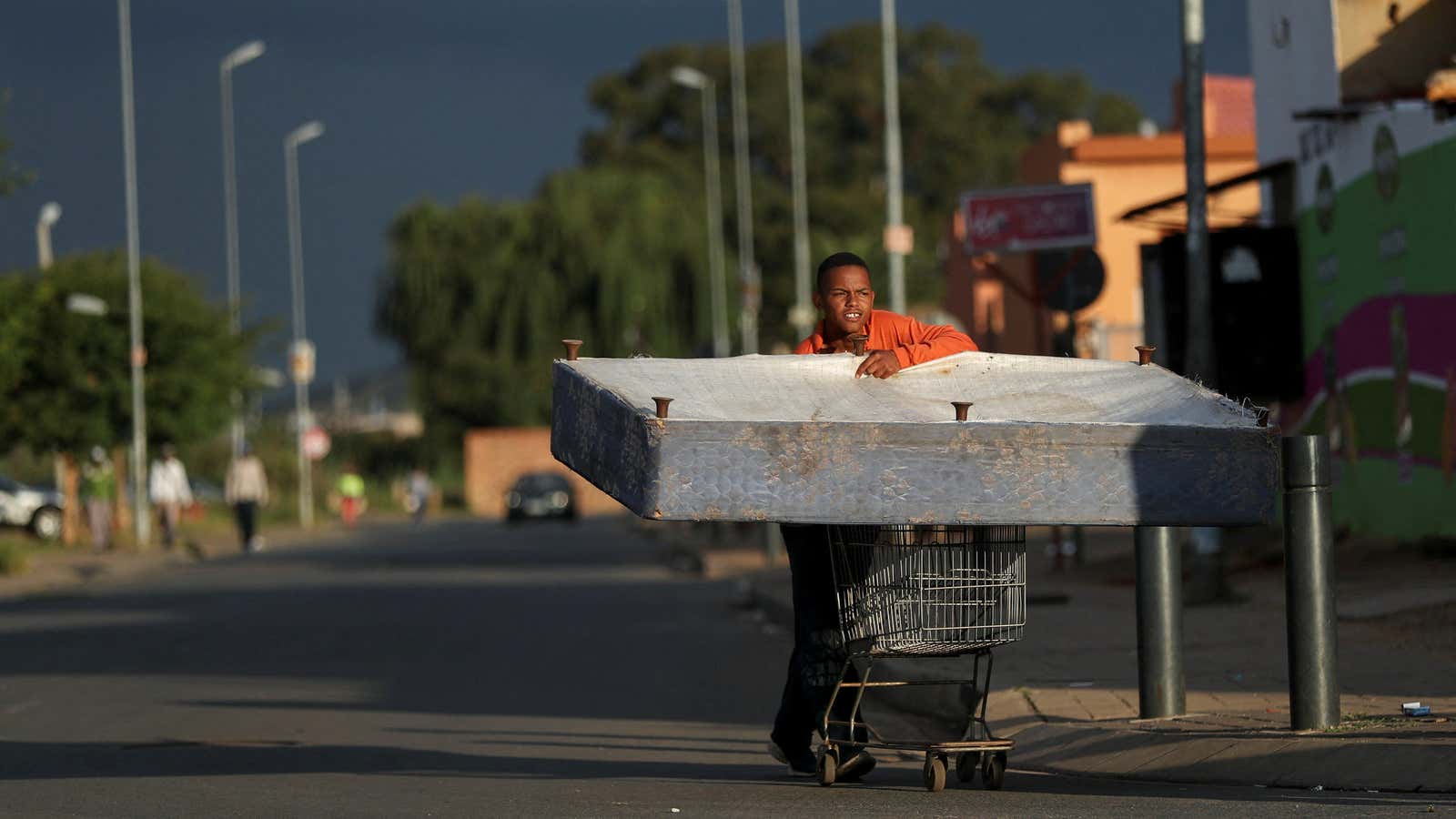 A man transports a bed on a trolley as the coronavirus disease (COVID-19) lockdown regulations ease in Soweto, South Africa, April 7, 2021. REUTERS/Siphiwe Sibeko