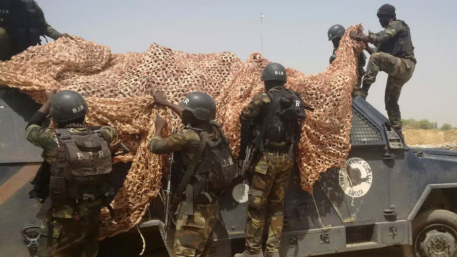 Cameroonian soldiers cover a Nigerian armoured vehicle used by Boko Haram insurgents.