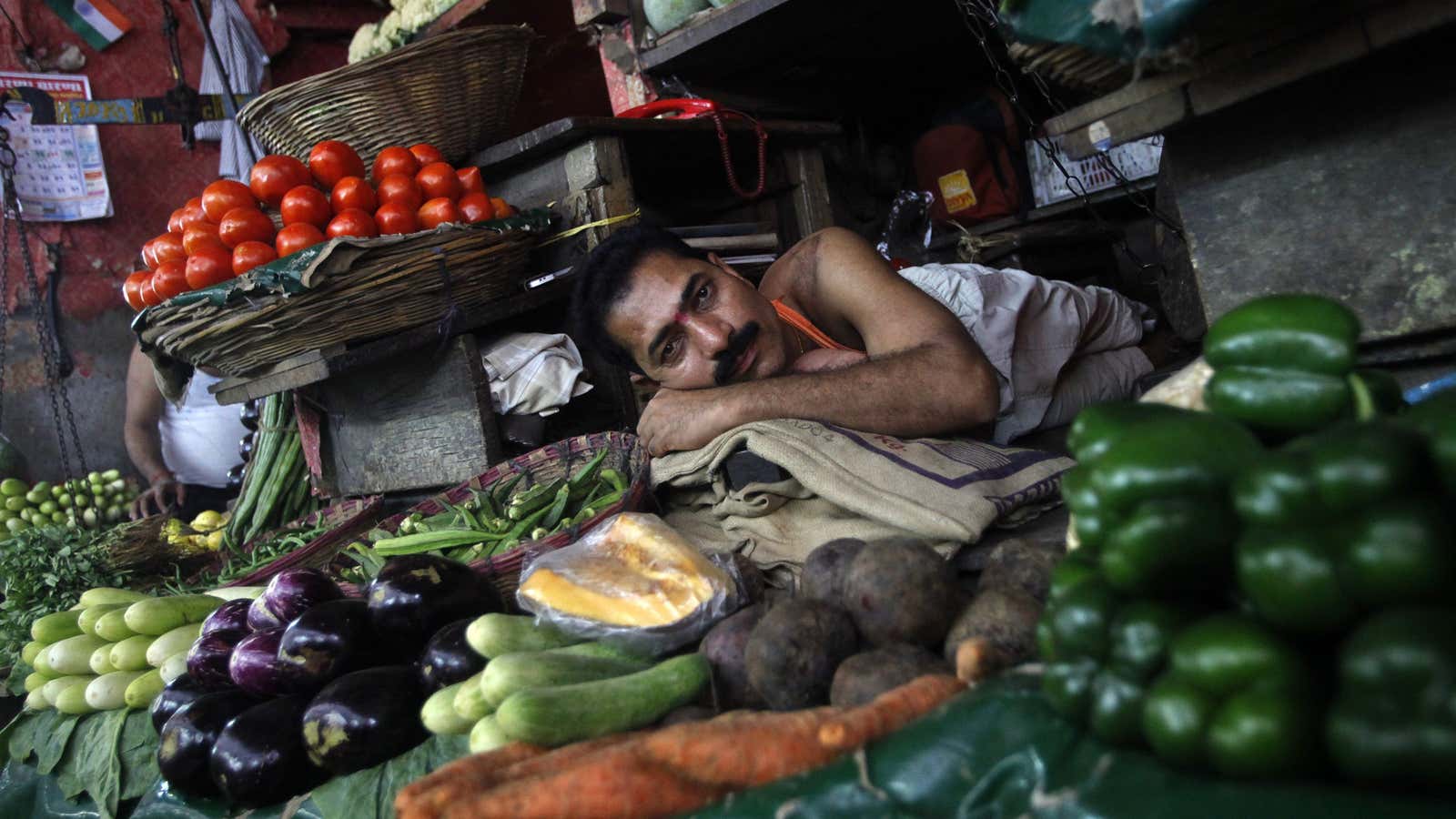 A vendor rests as he waits for customers at a vegetable market in Mumbai September 18, 2012. India’s annual consumer price inflation picked up in…