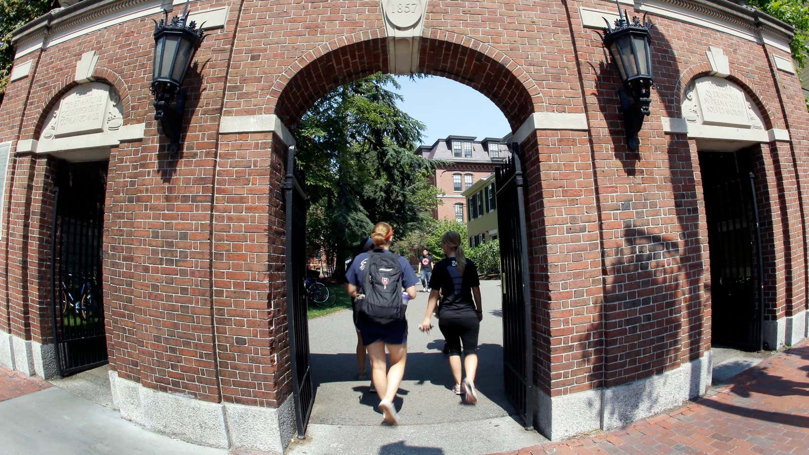Pedestrians walk through a gate on the campus of Harvard University in Cambridge, Mass. Thursday, Aug. 30, 2012. Dozens of Harvard University students are being…