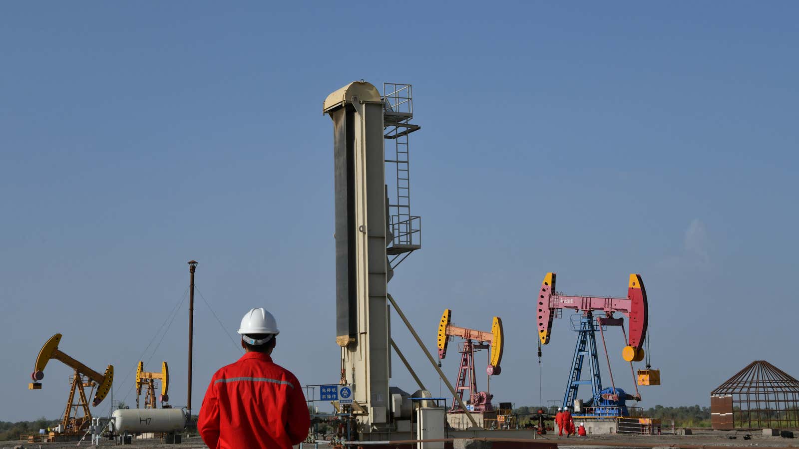 Workers are seen near pumpjacks at a China National Petroleum Corp (CNPC) oil field in Bayingol, Xinjiang Uighur Autonomous Region, China August 7, 2019. Picture…