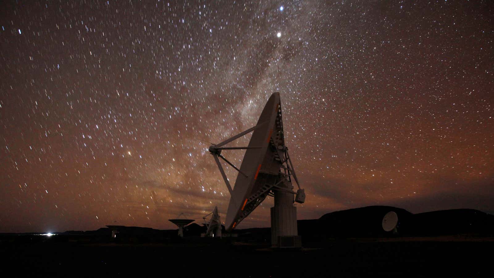 Night falls over radio telescope dishes in the remote Northern Cape province