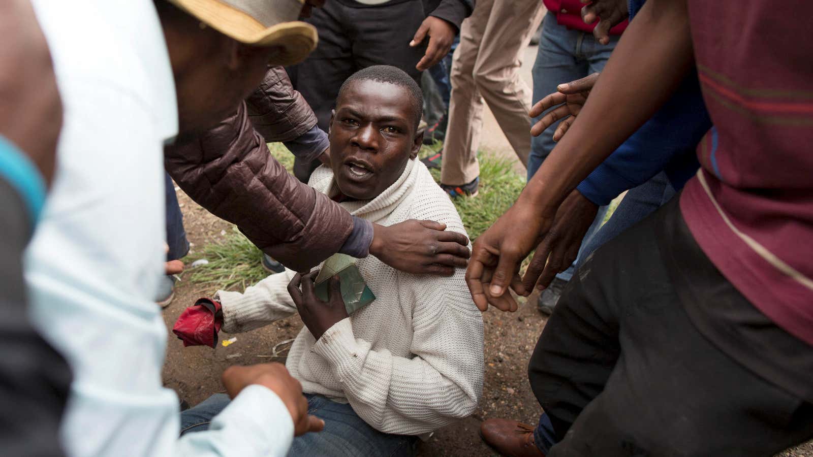A  man holds his South African identity document after being attacked by a xenophobic mob in Pretoria, South Africa, February 24, 2017.