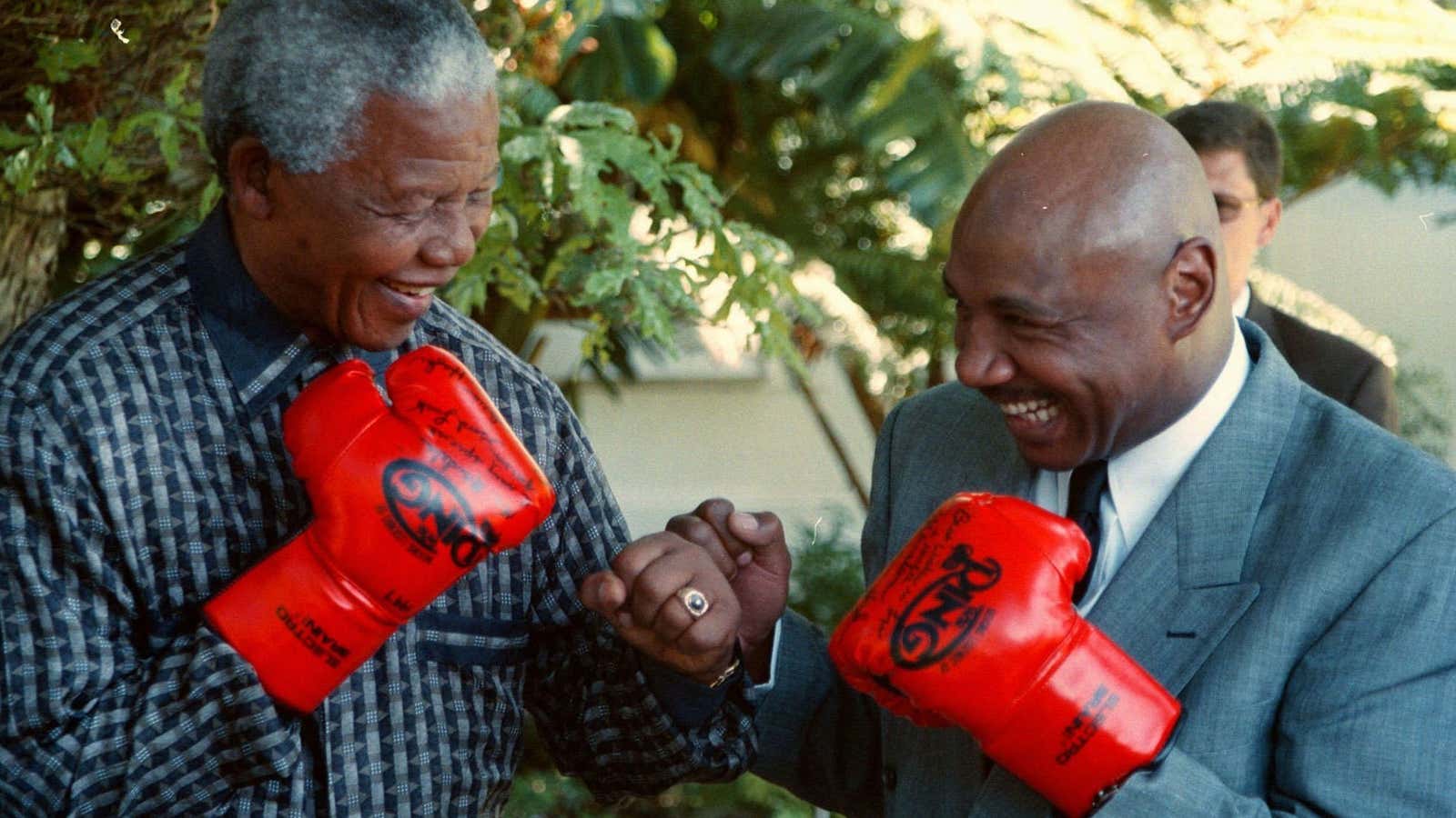 South African President Nelson Mandela, left, spars with boxing legend “Marvelous” Marvin Hagler, right, in 1997.