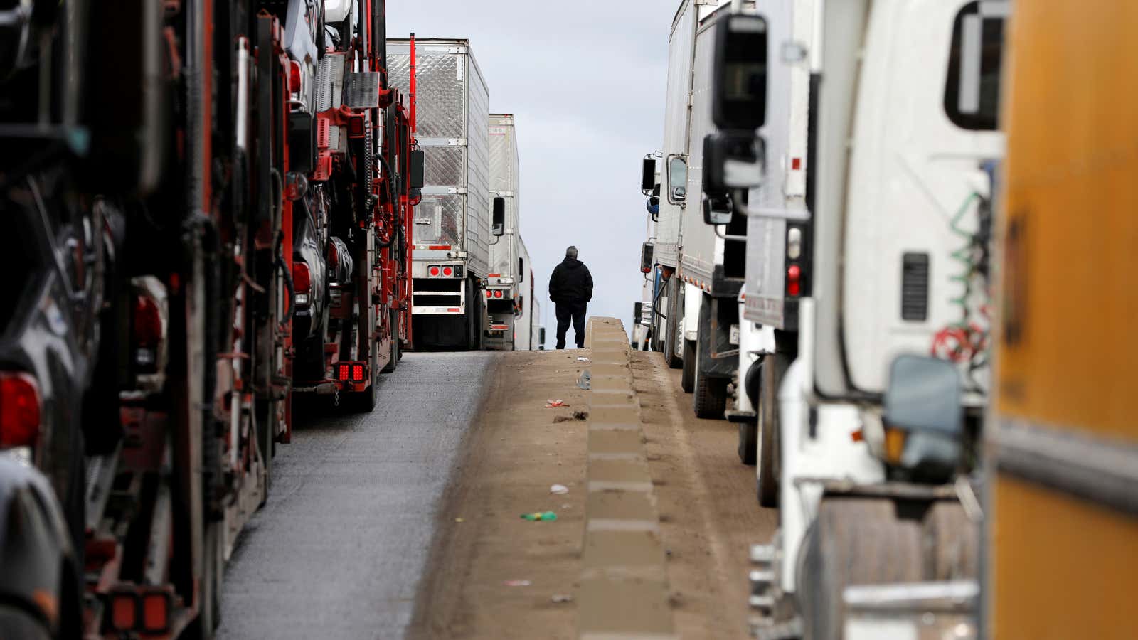 A man stands between trucks waiting in a long queue at border customs control to cross into the US  on April 3.