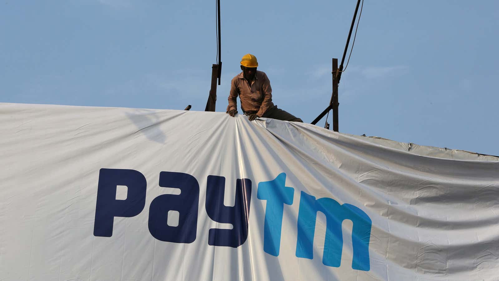 A worker adjusts a hoarding of Paytm, a digital payments firm, in Ahmedabad, India, January 31, 2019. Picture taken January 31, 2019. REUTERS/Amit Dave