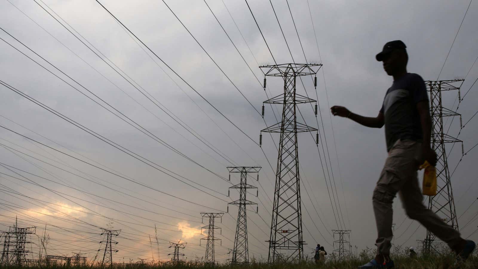 A man walks past electricity pylons in Soweto, South Africa.