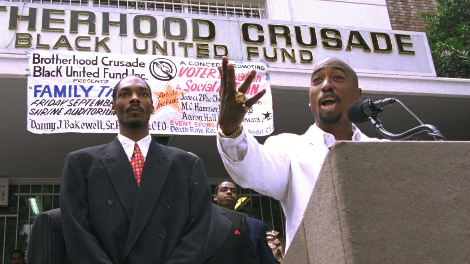 Rapper Tupac Shakur, right, speaks as fellow rap artist Snoop Dogg listens during a voter registration rally in South Central Los Angeles, in Aug. 1996.