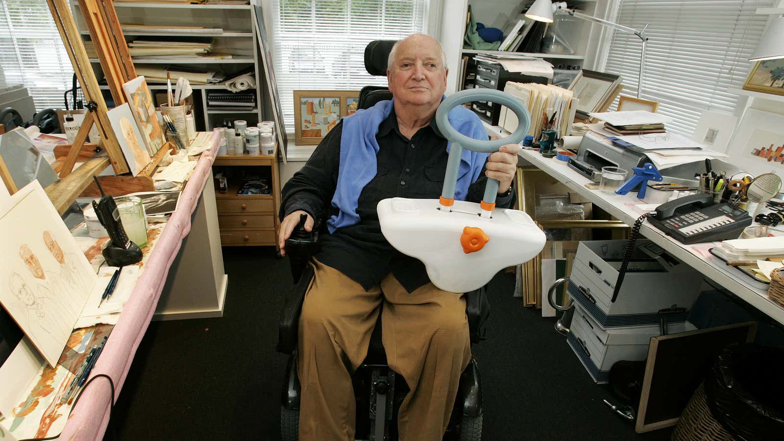 Michael Graves at his studio in 2009, holding a bathtub handle  he designed.