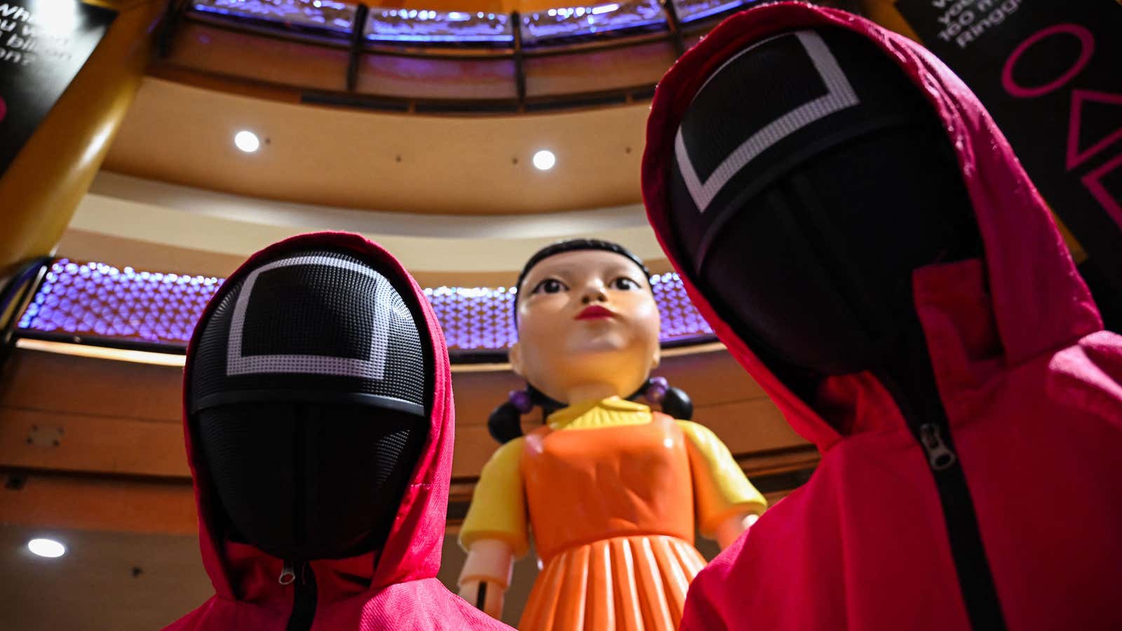 “Squid Game” cosplayers stand next to a replica of the show’s giant doll in Kuala Lumpur, Malaysia.