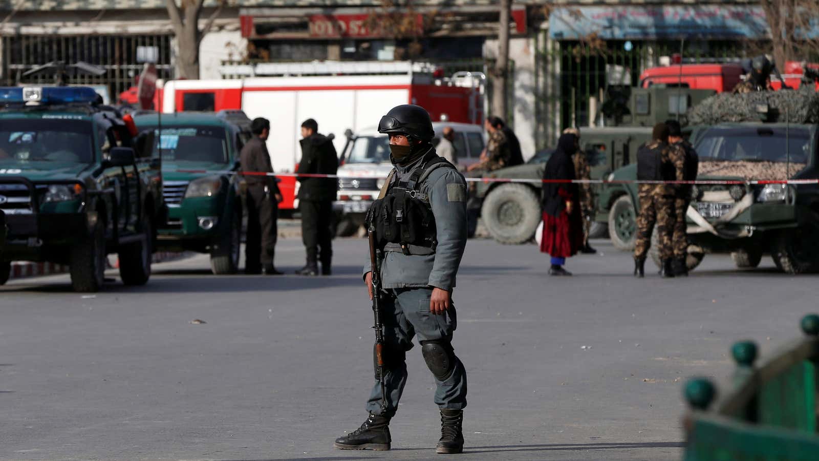 An Afghan policeman keeps watch at the site of today’s car bomb attack in Kabul.