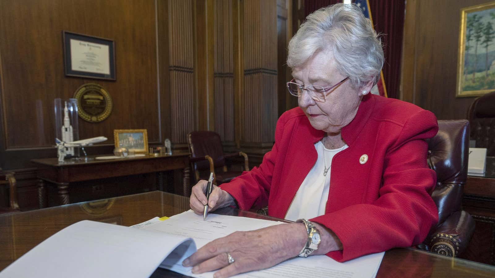 Alabama governor Kay Ivey signs a bill that virtually outlaws abortion in the state.