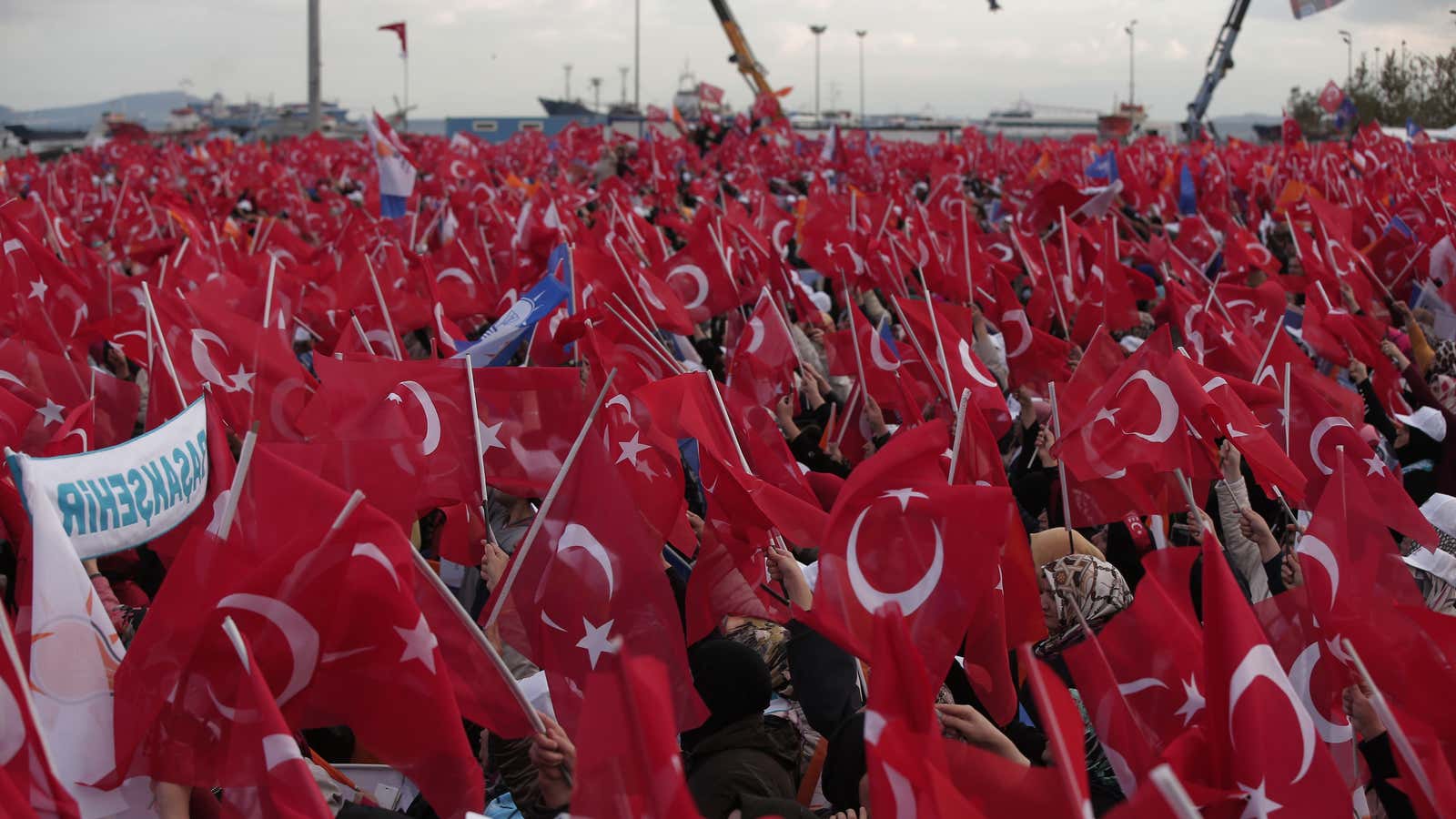 Supporters of Turkish prime minister Ahmet Davutoglu and leader of the Justice and Development Party (AKP), wave Turkish flags as they wait for him to arrive to deliver a speech at a rally in Istanbul on Oct. 25.