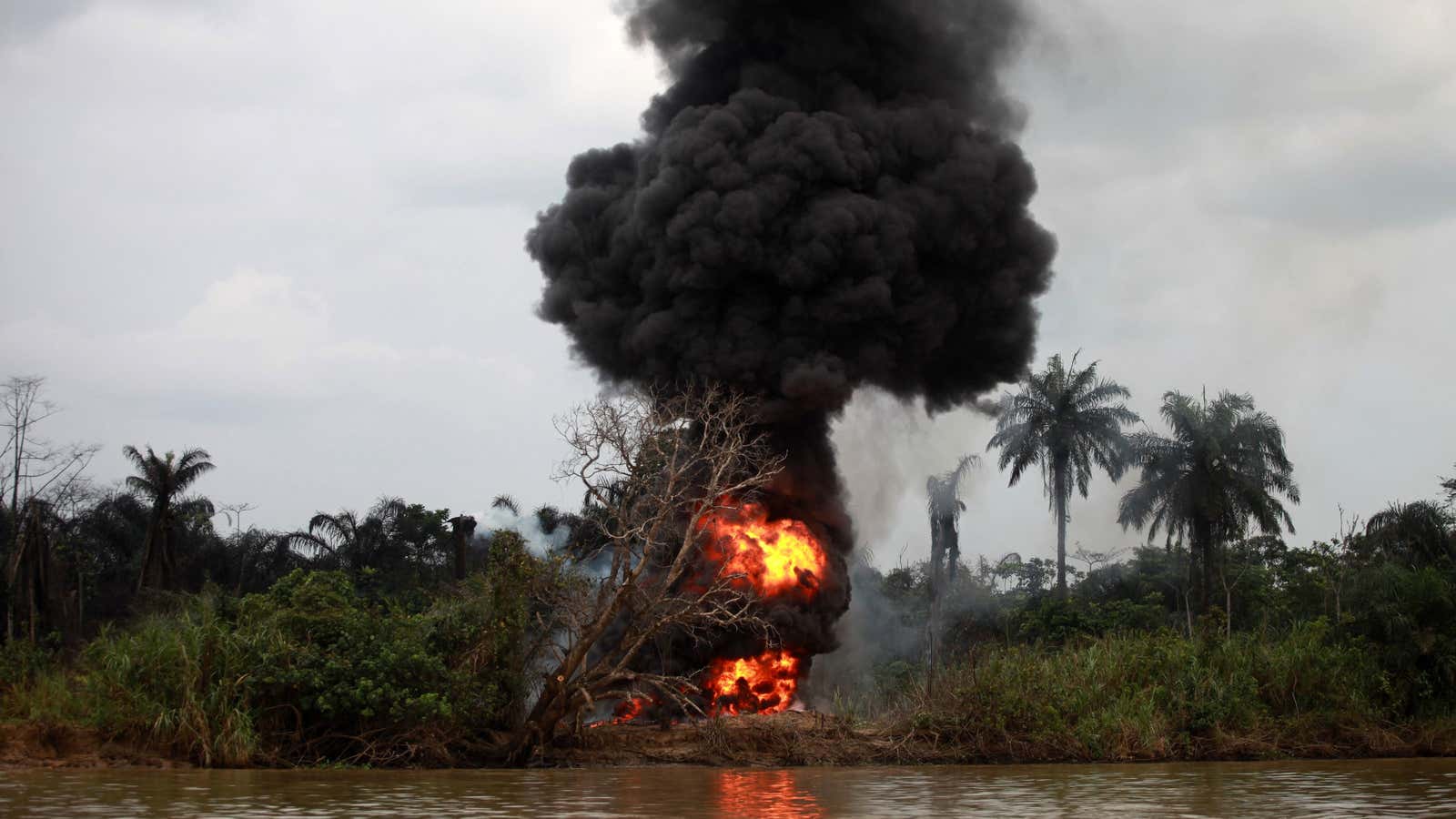 Smoke rises as an illegal oil refinary burns after a military chase in NIgeria’s delta region.