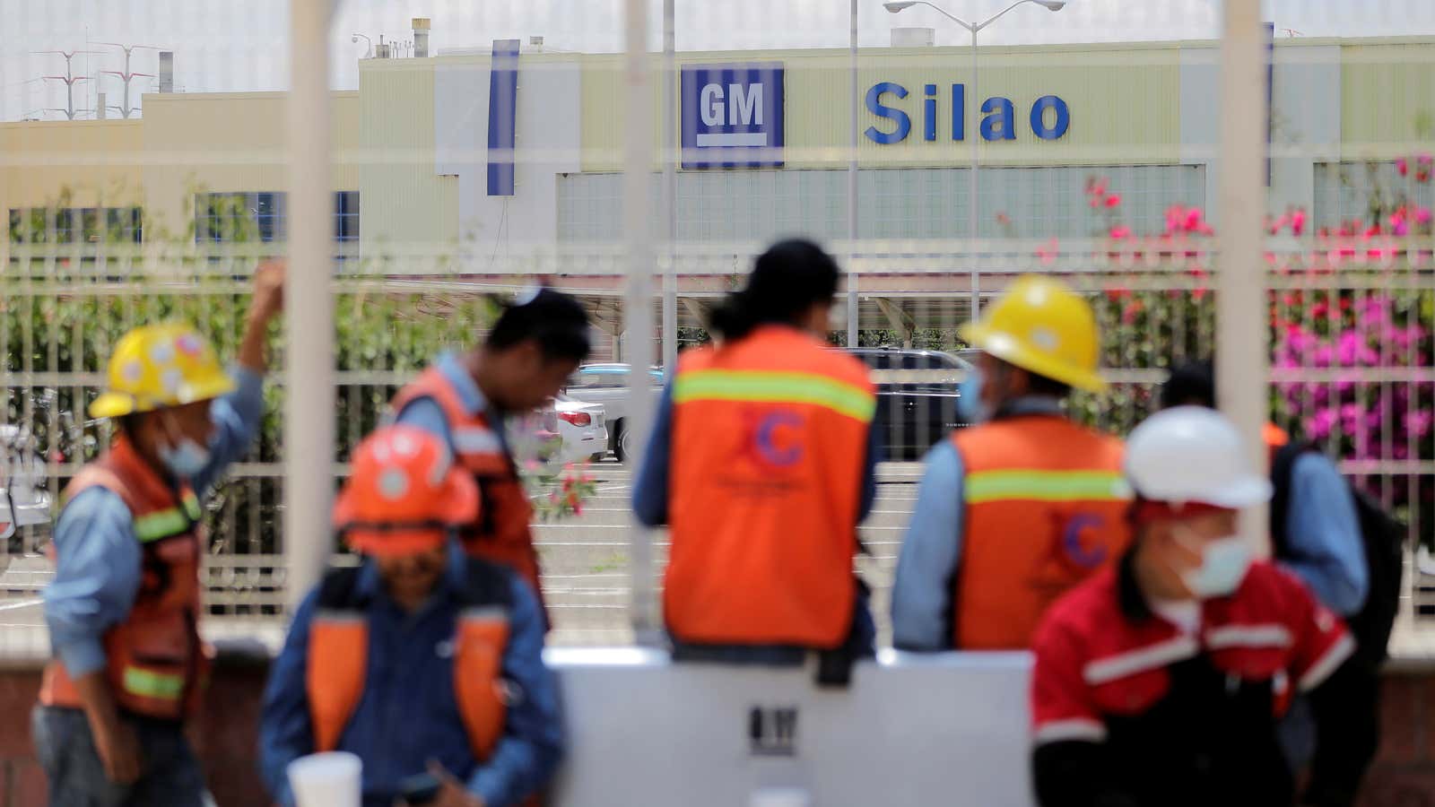 Workers wait outside the General Motors plant in Silao, Mexico.