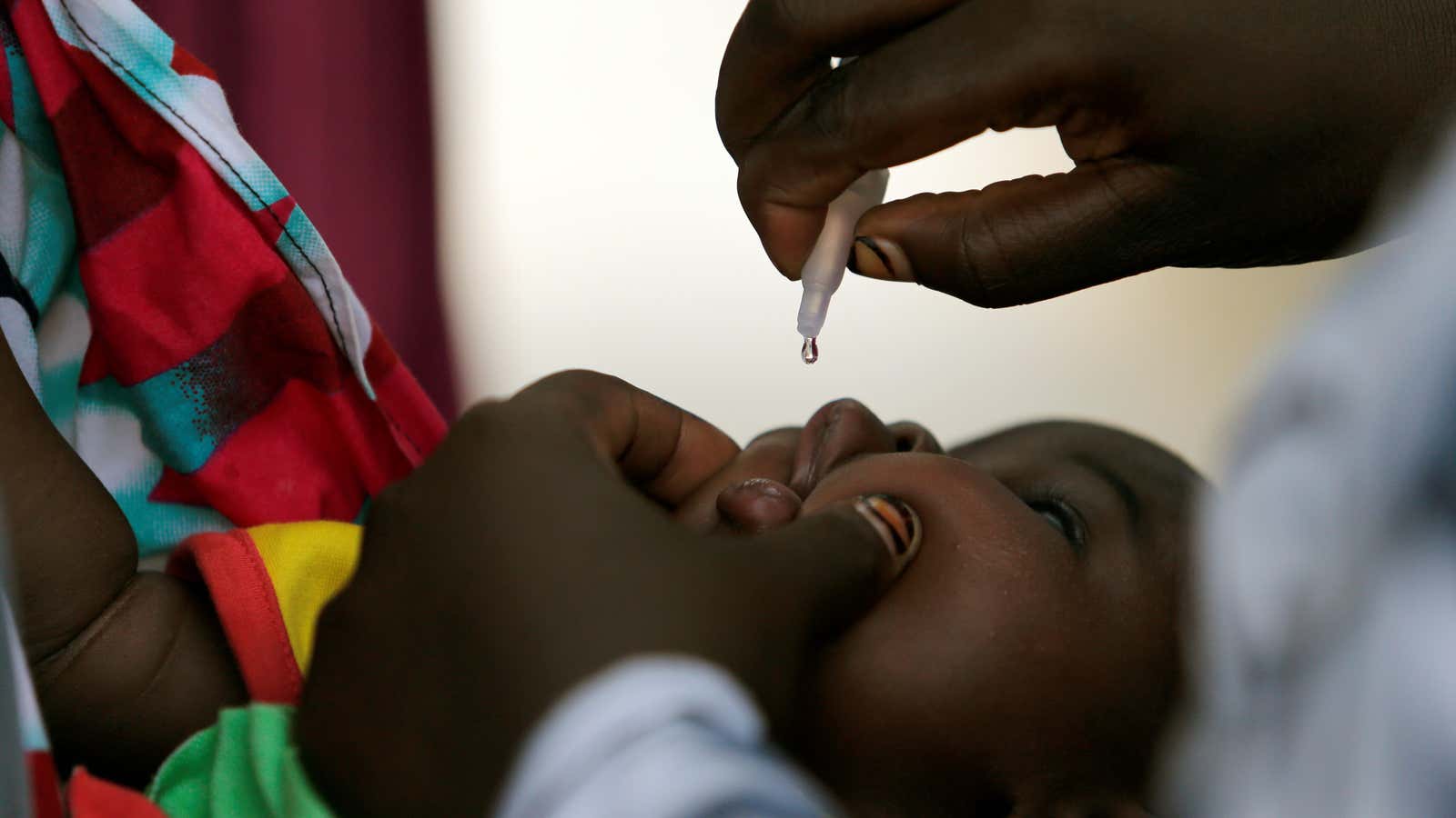 A child is given a dose of polio vaccine at an immunisation health centre, in Nigeria