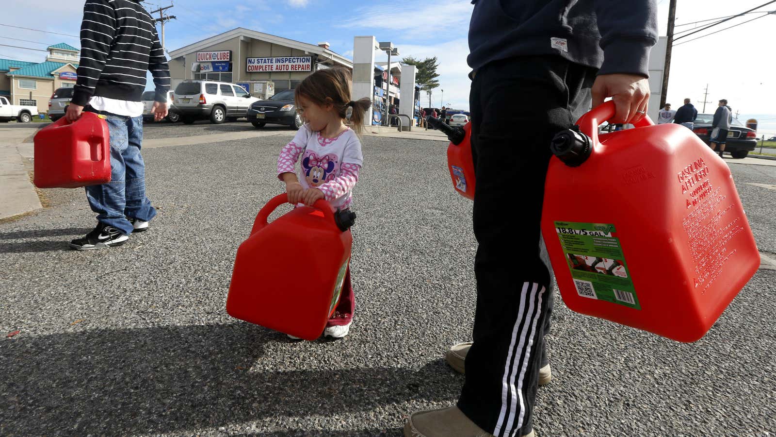 Sandy’s effects, big and small: Residents of New Jersey try to fill up containers with petrol.