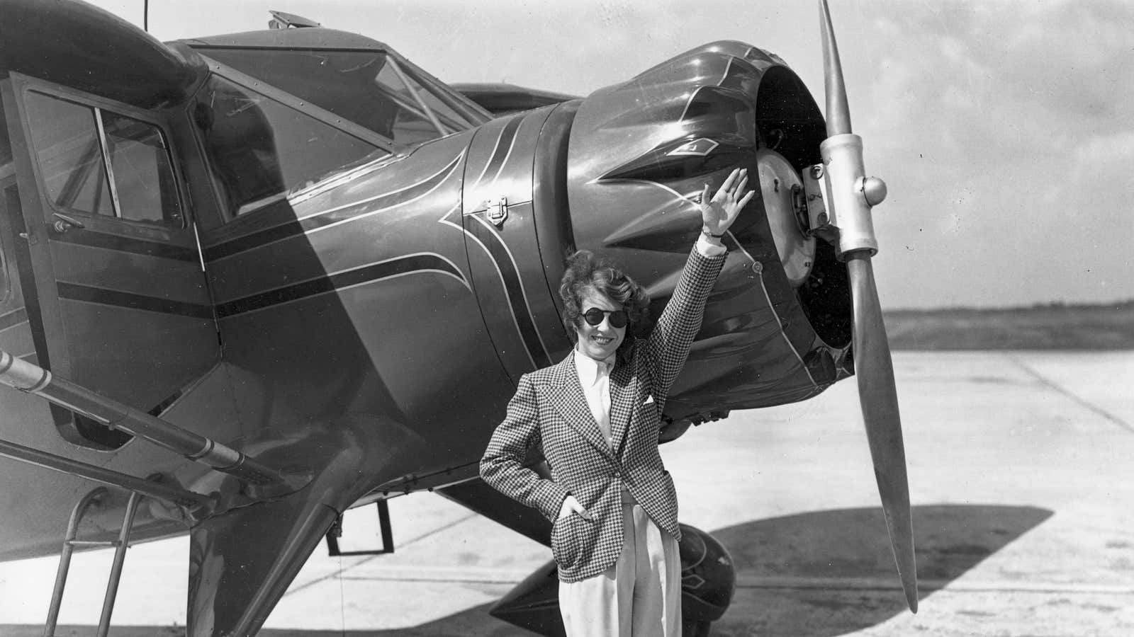 Ruth Chatterton, actress and licensed pilot, waves from beside her airplane before taking off to pace 36 pilots, including 10 women, in the cross-country air…