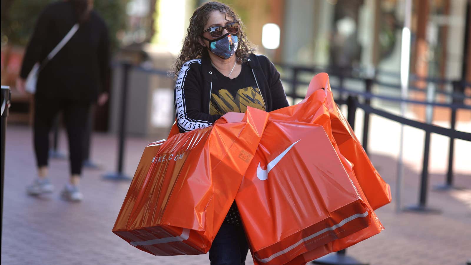 A woman carries Nike shopping bags at the Citadel Outlet mall, as the global outbreak of the coronavirus disease (COVID-19) continues, in Commerce, California, U.S.