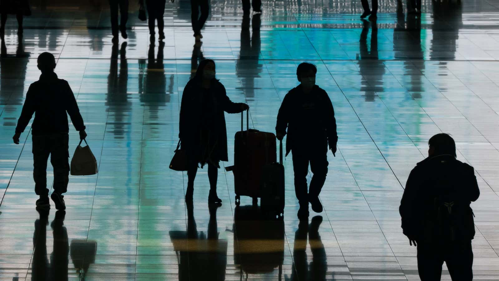 Travelers walk with their luggages at the arrival hall of the Hong Kong International Airport on December 30, 2022.