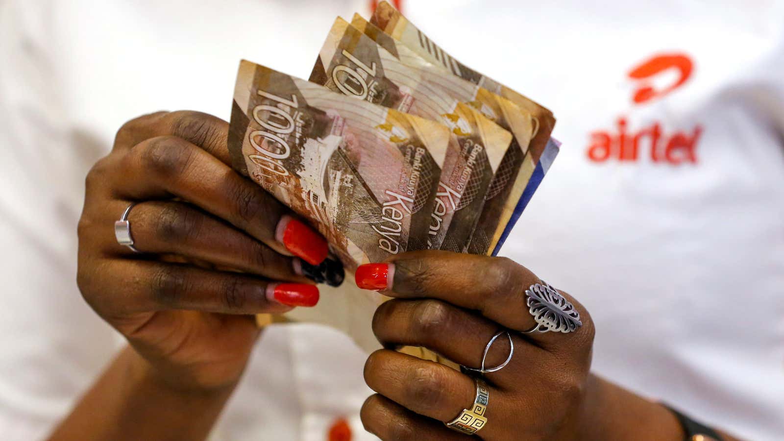 An employee counts money inside a mobile phone service centre operated by Airtel Kenya in Nairobi.
