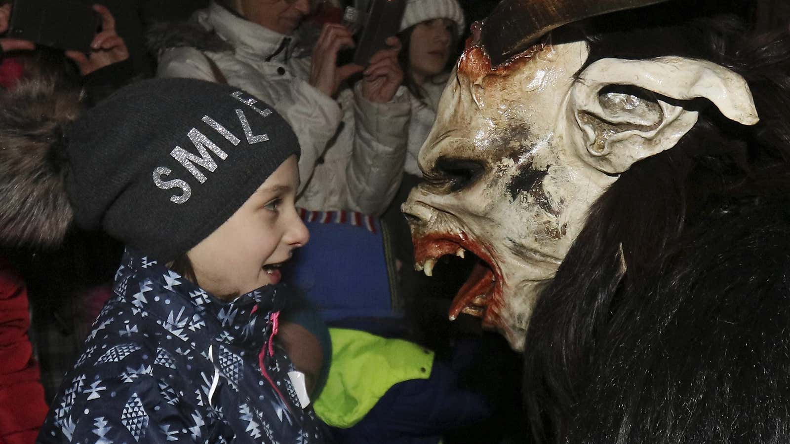 A Krampus scares spectators during a traditional Krampus run in which men and women dress up as pagan Krampus figures to scare people in Hollabrunn, Austria, Saturday, Dec.1, 2018. (AP Photo/Ronald Zak)