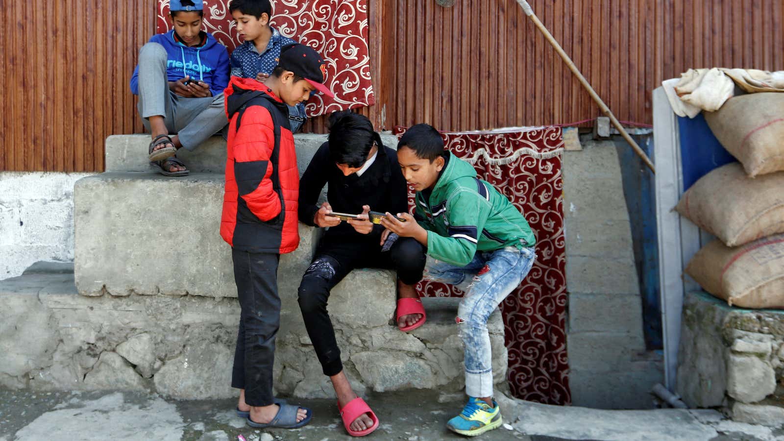 Children play games on their mobile phones.