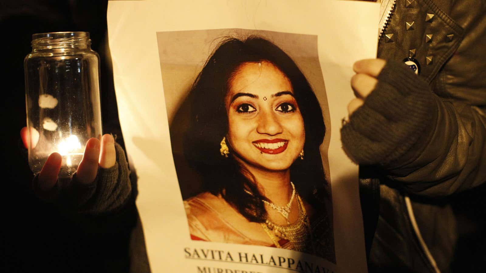 An activist for abortion legalization holds up an image of Savita Halappanavar, who died of a miscarriage after being denied an abortion in 2012.