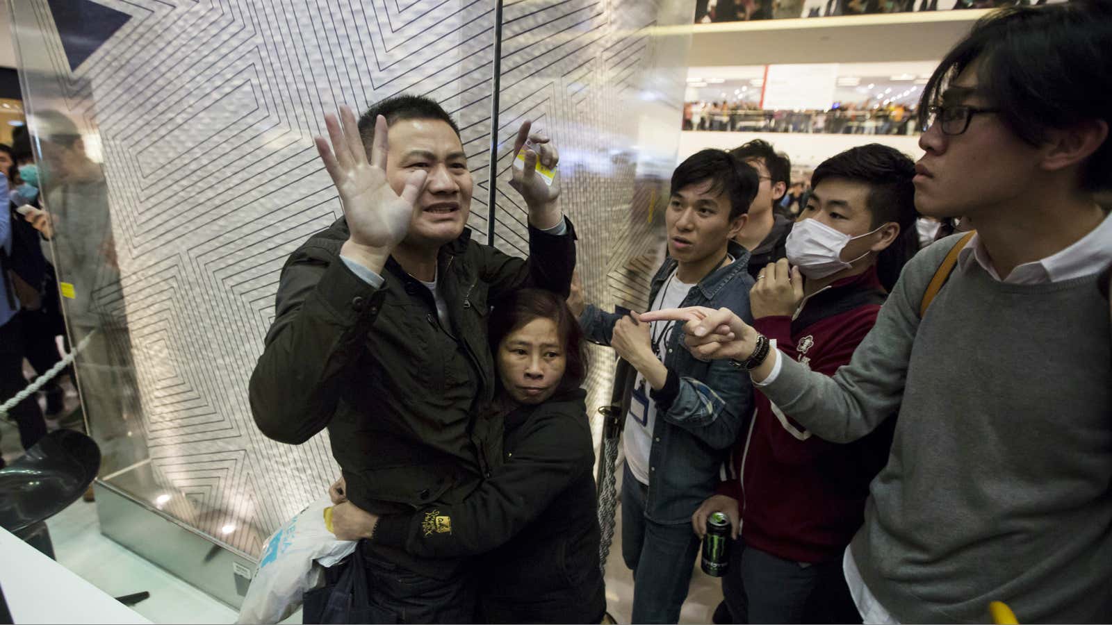 A protester restrains a mainland Chinese traveller (L) who allegedly beat other protesters during a demonstration inside a shopping mall in Hong Kong.