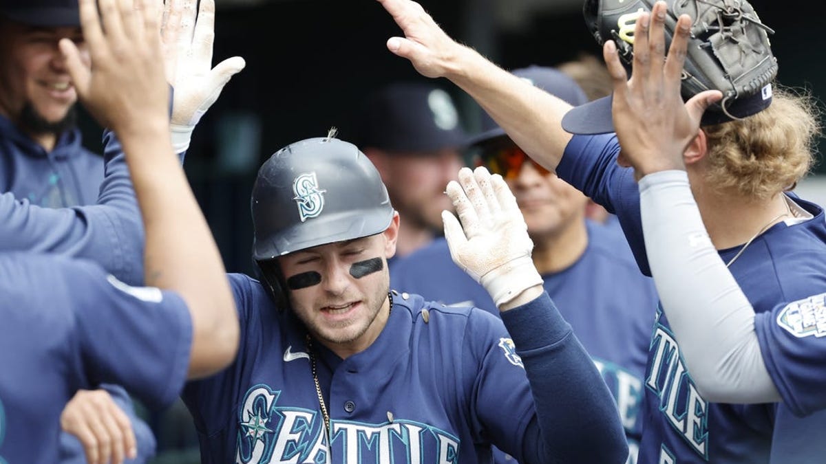 Cal Raleigh of the Seattle Mariners is congratulated by teammates