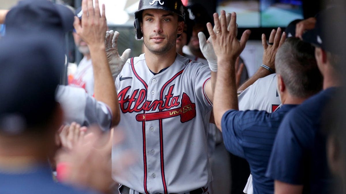 Atlanta Braves' Nicky Lopez scores a run behind New York Mets